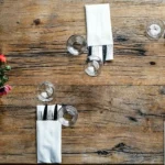Vue du dessus d’une table dressée avec assiettes et couverts au restaurant La Table de Trois en Nouvelle-aquitaine.